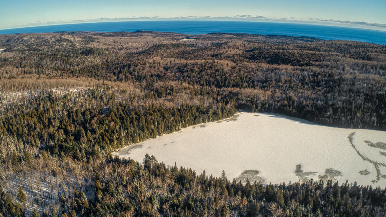 Forest and a snow-covered lake at George H. Crosby Manitou State Park, MN