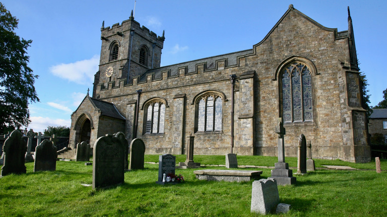 Stone St. Leonard's Church and graves in the village of Downham, England