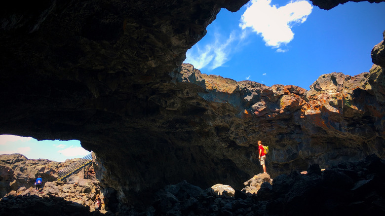 Hikers move through stone arches in Craters of the Moon, Idaho