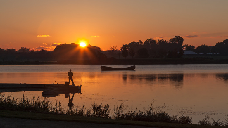 Man fishing at Independence Grove Forest Preserve at sunrise, Libertyville, Illinois