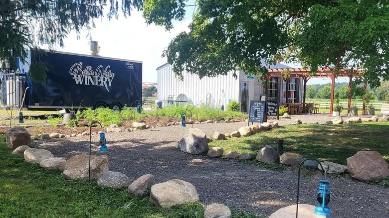 The Bella Vista Winery in Webberville, Michigan, showing a path leading to a small tasting room.