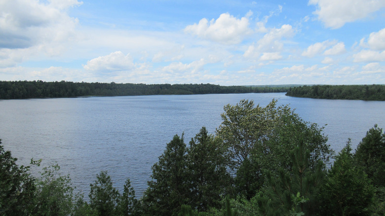 The Mio Dam Pond as seen from above the trees, with blue water and trees all around