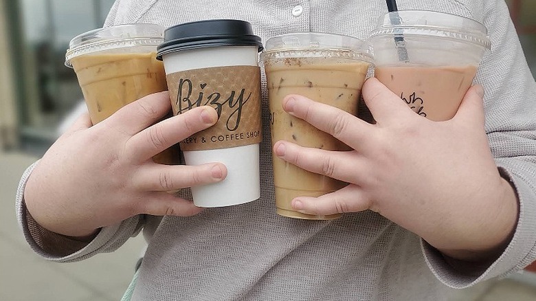 A person holding four different coffees from Bizy Dips