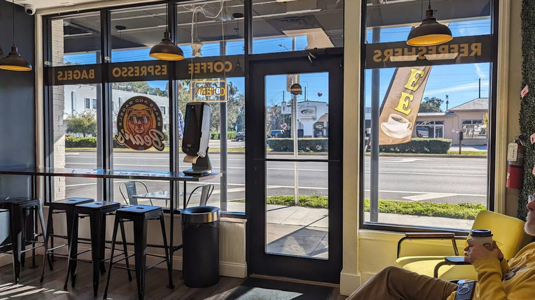 Interior of Bear's Beans and Bagels, with large front windows, café seating, and a customer relaxing with a coffee