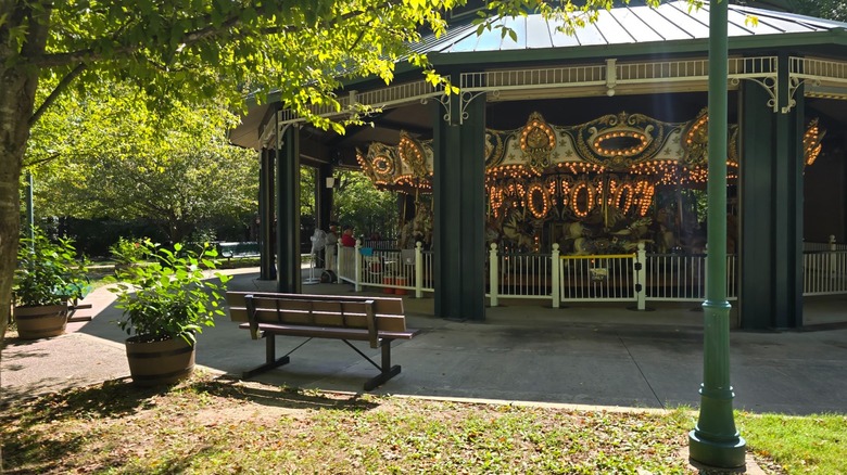 The carousel at Dan Nicholas Park shaded by trees.