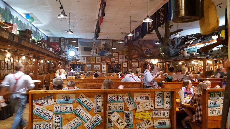 A scene inside the busy Lambert's Cafe featuring the back of a booth covered in license plates