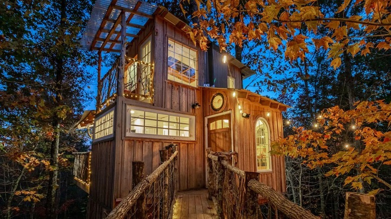 The Whipporwill Retreat, a glowing modern treehouse in an autumn forest, in Trenton Georgia