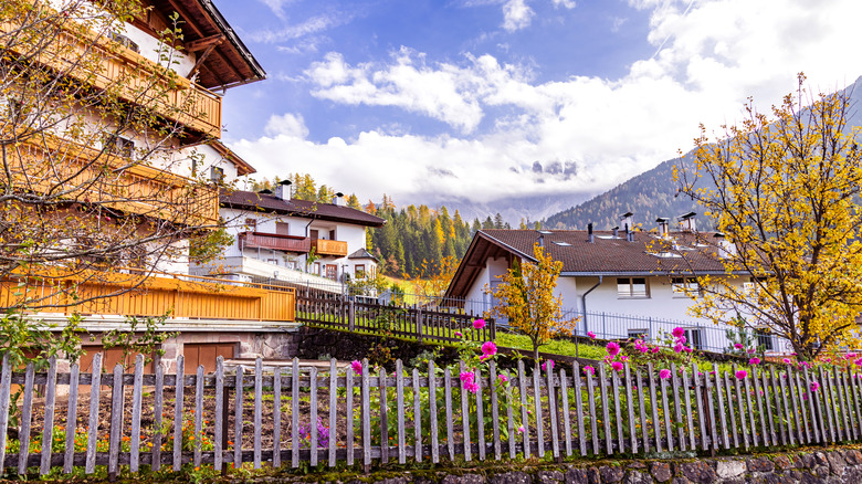 Santa Maddalena village in Val di Funes during the day with a small fence in the foreground.