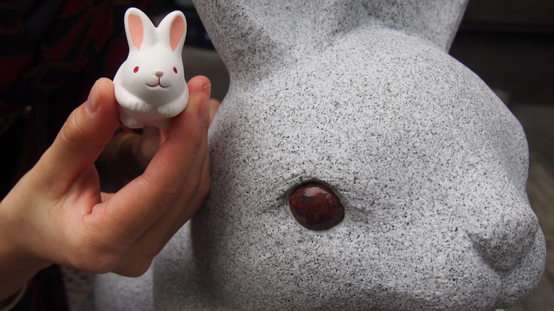 Someone offering a rabbit toy to the rabbit statue at Okazaki Shrine in Kyoto, Japan
