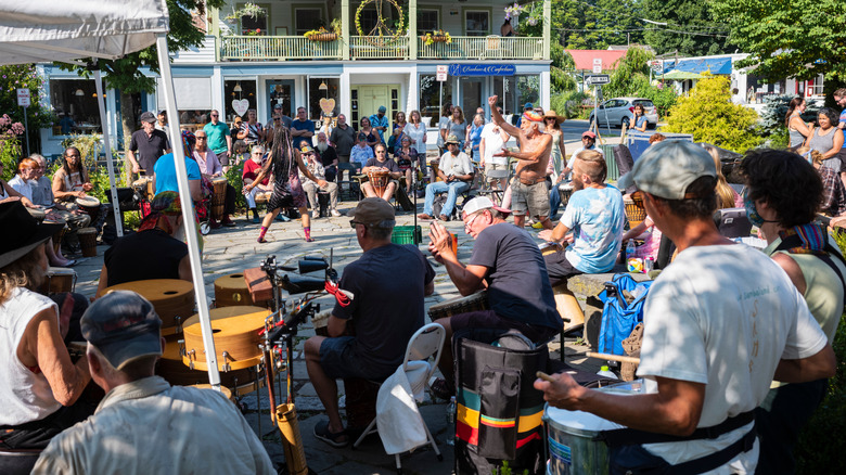 A man and woman dance as a drum circle plays in the Village Green in Woodstock