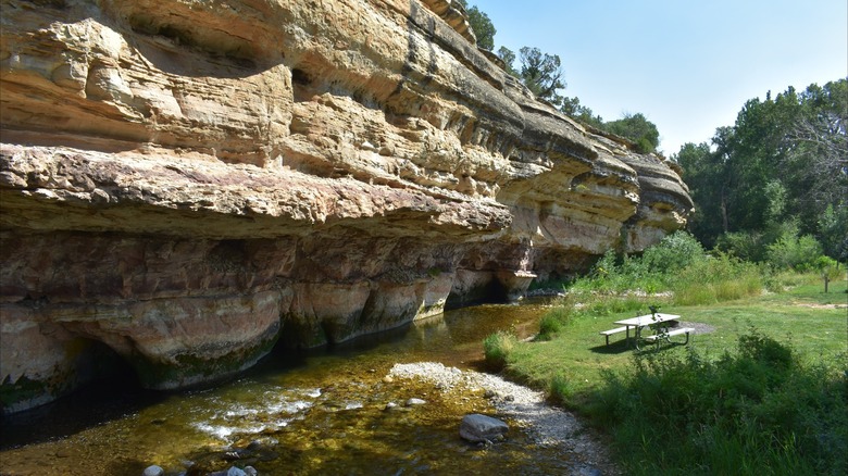 Picnic table near the sandstone cliff and Medicine Lodge Creek at Medicine Lodge Archaeological Site, Wyoming
