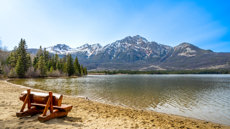 Wooden bench on beach at Pyramid Lake, with mountains visible on far side of lake