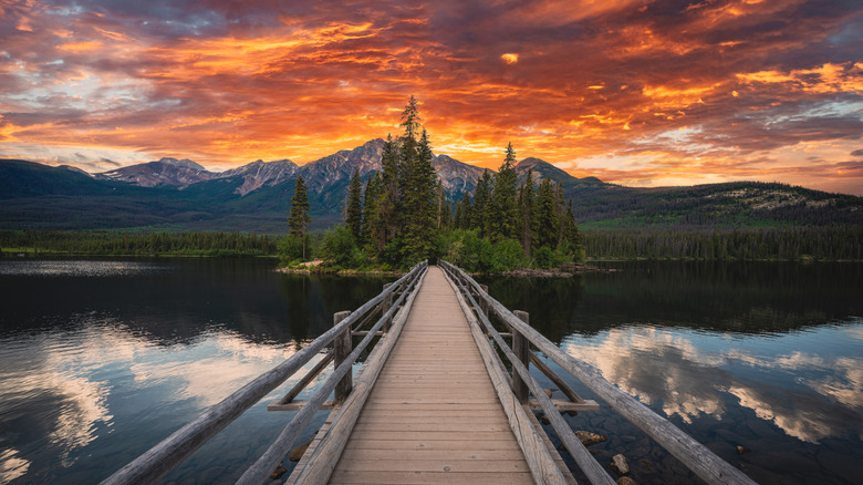 Mountains and orange clouds behind Pyramid Island at sunset, staring down bridge to Pyramid Island