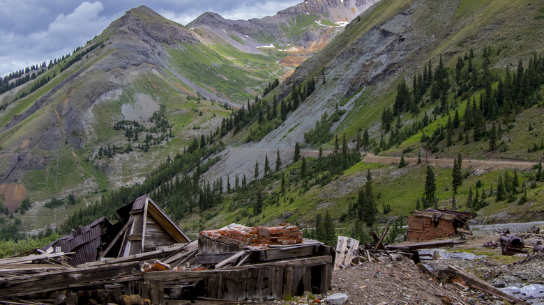 The ruins of Telluride's Tomboy ghost town with Imogene Pass and mountains in the distance.