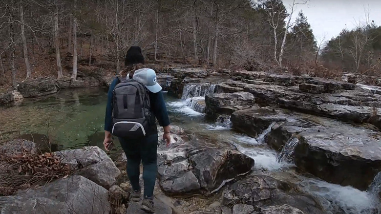 A hiker walks by the falls in Hercules Glades WIlderness