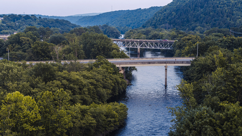 Bridge going over Lehigh River in Lehighton, Pennsylvania during the day with mountains and trees in the background.