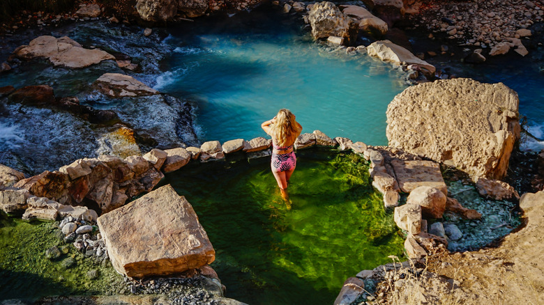 A woman stands in Fifth Water Hot Springs in Diamond Fork, Utah