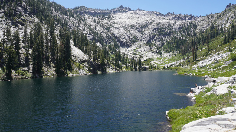 An alpine lake in the Trinity Alps Wilderness area surrounded by snow-covered mountains.