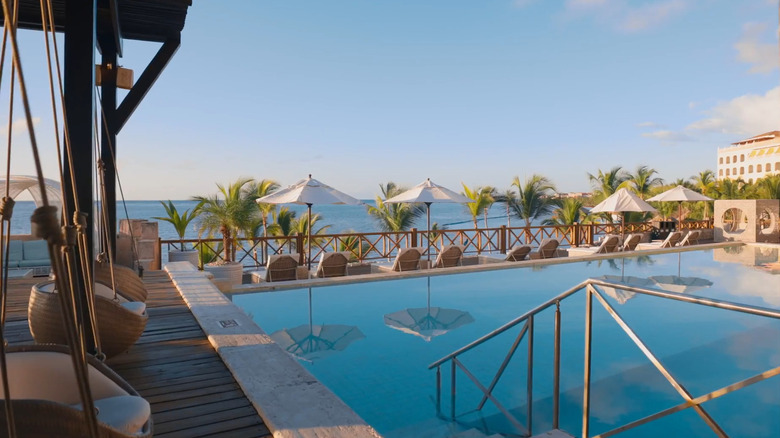 Pool and loungers with palm trees at Sanctuary Cap Cana
