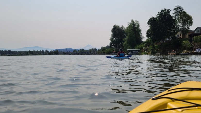 Yellow kayak on Fairview Lake, Fairview, Oregon, with another kayaker in the distance