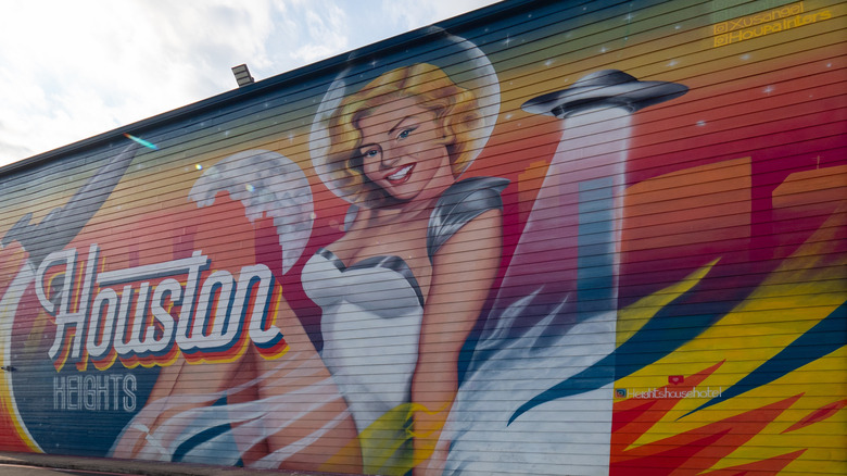 A colorful mural of a blonde woman and a UFO spaceship in Houston Heights, Houston, Texas