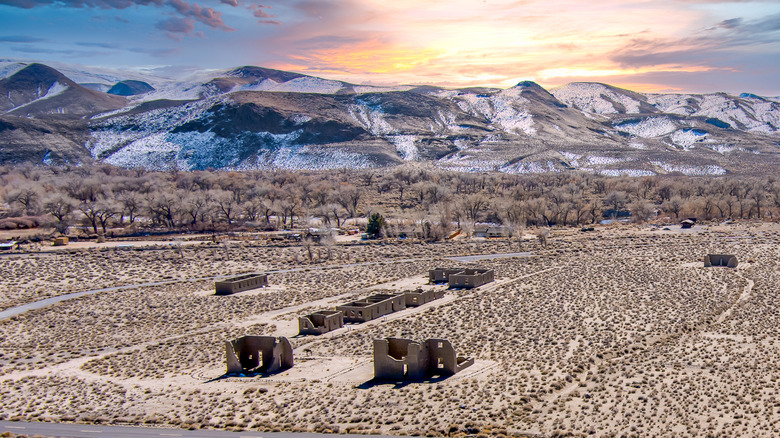 An aerial view of Fort Churchill State Park's abandoned adobe structures with a pink, yellow and pale blue sky