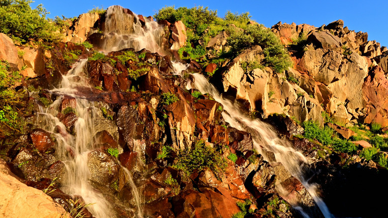 Waterfall flowing down over rocks in sunlight