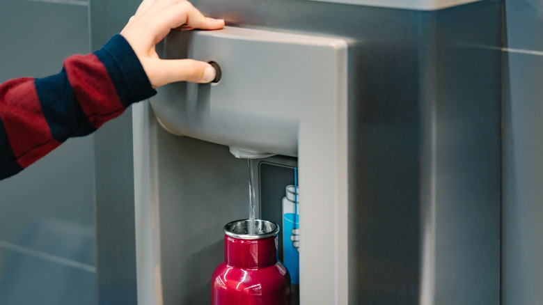 Person filling up water bottle