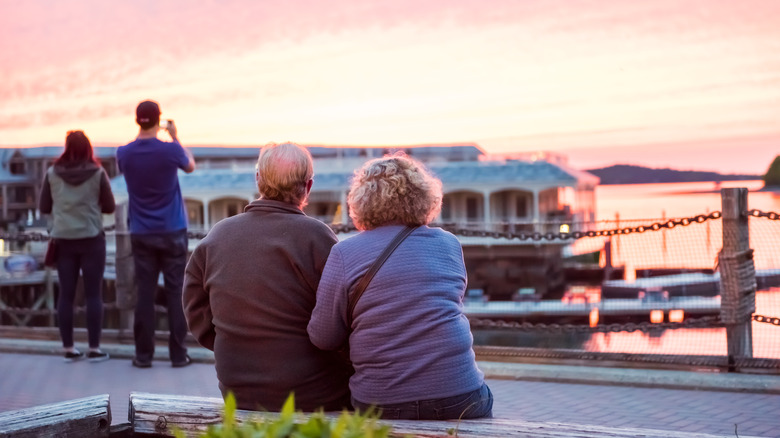 Older couple looking at sunset over water