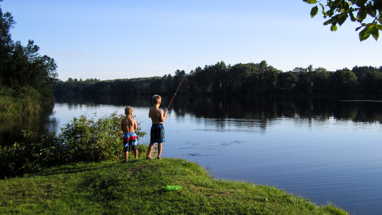 Two kids fish in Kennebec River in Skowhegan, Maine