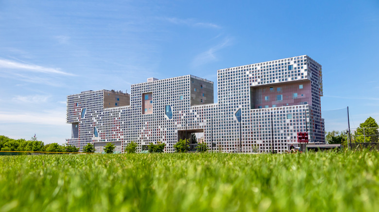 Simmons Hall, a dorm at MIT, surrounded by grass and blue sky.