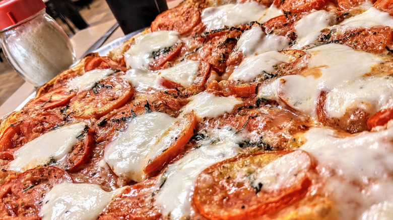 A closeup of a delectable pizza margherita with melty cheese and tomatoes at Zuppardi's Apizza in West Haven