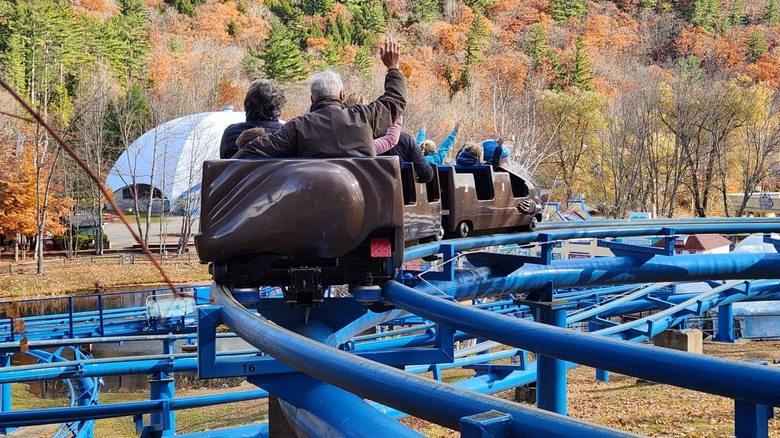 riders of varying ages ride a rollercoaster at Storyland