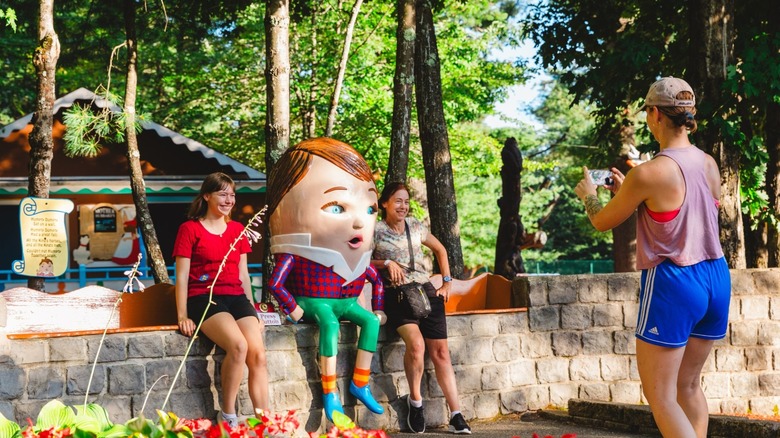 Women take picture with Humpty Dumpty statue at Storyland