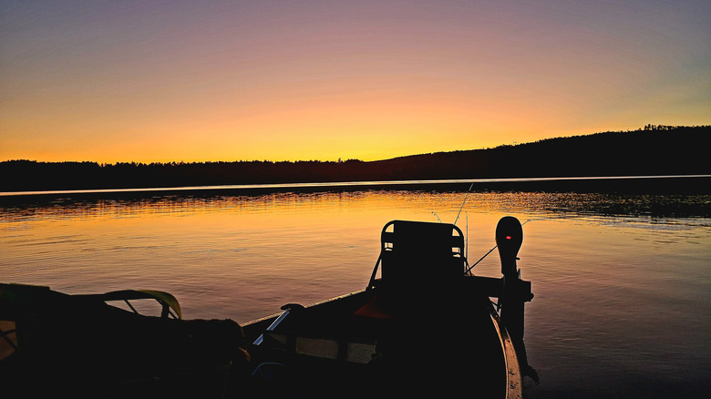 A fishing boat on the calm water at sunset near the North Littleton Launch on Moore Reservoir, along the Connecticut River, in between New Hampshire and Vermont