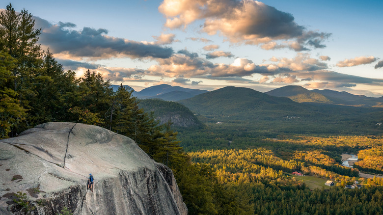 A climber descending down a cliff mountain side in New Hampshire's white mountains