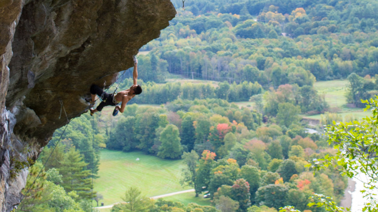 A man climbs an overhanging rock face in Rumney, New Hampshire