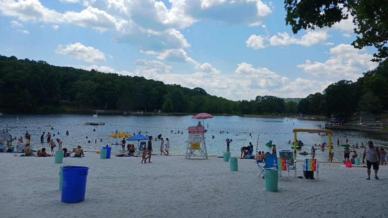 People enjoying the white-sand beach and water at Tomahawk Lake in Sparta, New Jersey