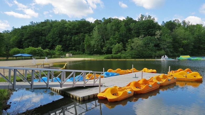 Sunrise Lake at Lewis Morris County Park with yellow paddle boats and an inflatable obstacle course on it.