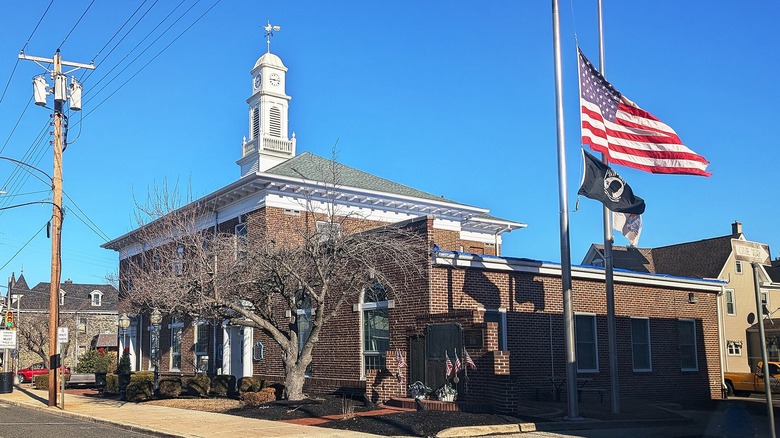 Swedesboro Borough Hall with an American flag on one side and other historic buildings in the distance