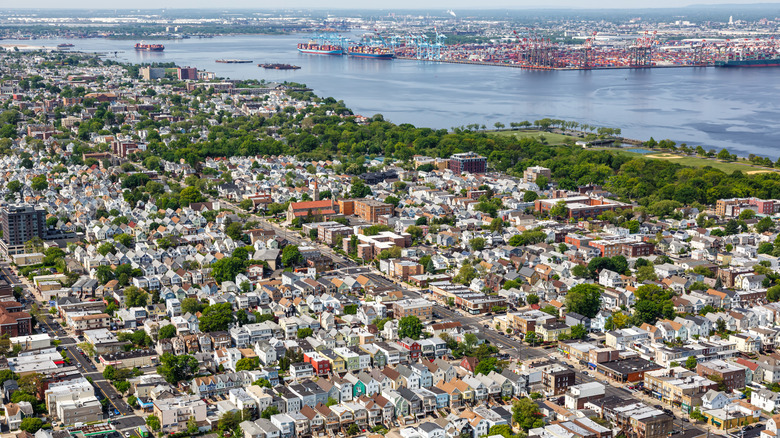 The suburban sprawl of Bayonne with houses, trees, and waterfront parks overlooking a bay in New Jersey and New York.