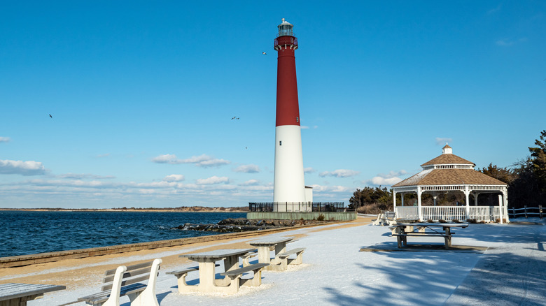 Barnegat Lighthouse and a gazebo with benches by the coast in New Jersey