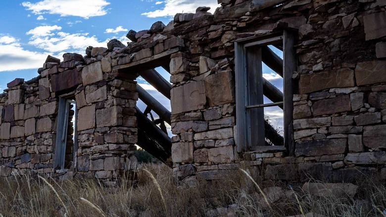 A crumbling stone wall with windows in Loma Parda, New Mexico