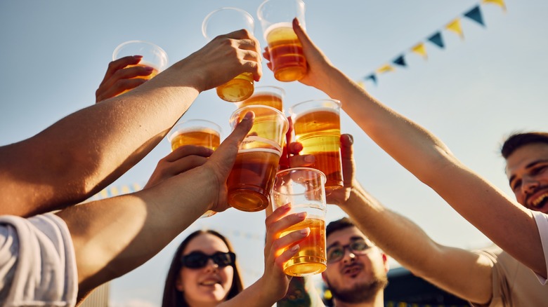 Friends clinking cups of beer