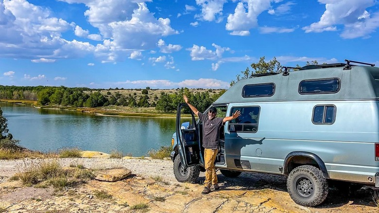 An excited man spreading his arms out in front of a camper van at Clayton Lake State Park, in New Mexico.