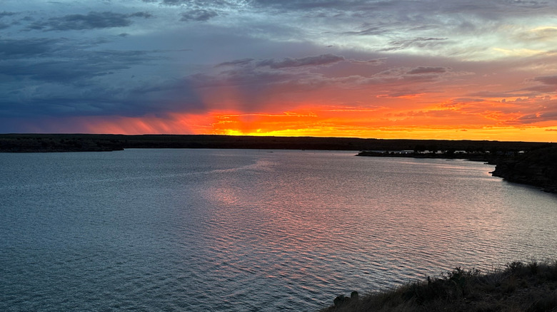 An orange and yellow sunset over Ute Lake during a cloudy day.