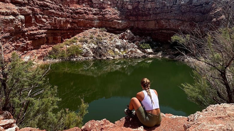 woman sitting by lake