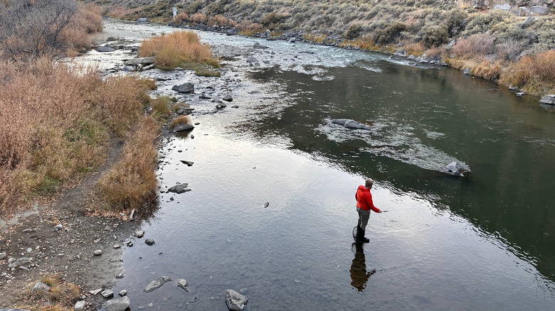 A man fishing in mountain lake