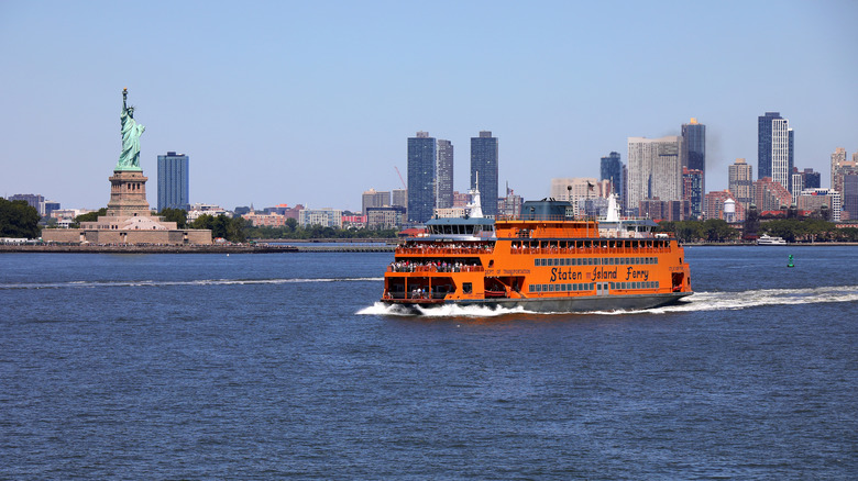 Staten Island Ferry crossing in front of the Statue of Liberty.