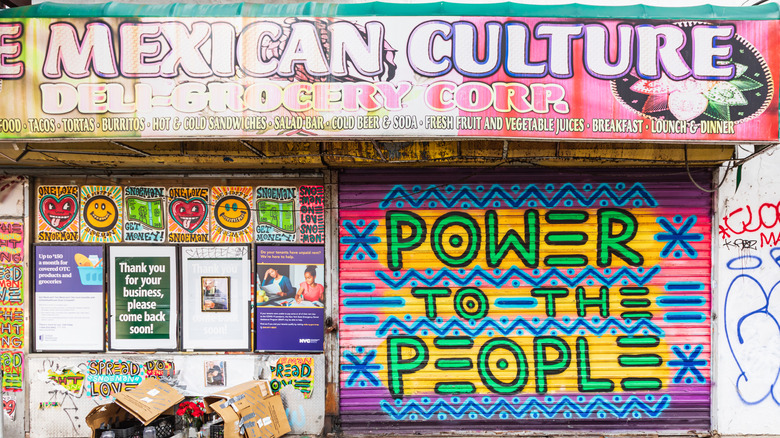 Mexican deli and grocery shop with colorful signs and art in Washington Heights, NYC
